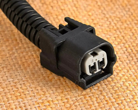 Solid VCM Bypass Harness And Resistor Plug Set For 3.5L V6 Engine connector close-up view, features dual pins and black plastic housing.