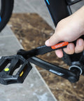 Close-up of hand using Ultra Slim Bike Cone Wrench Set For Tight Hub Gaps Cone Spanner Tool Kit on bicycle pedal crank.