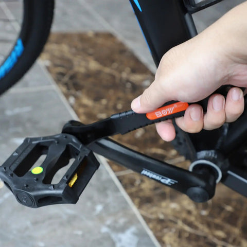 Close-up of hand using Ultra Slim Bike Cone Wrench Set For Tight Hub Gaps Cone Spanner Tool Kit on bicycle pedal crank.
