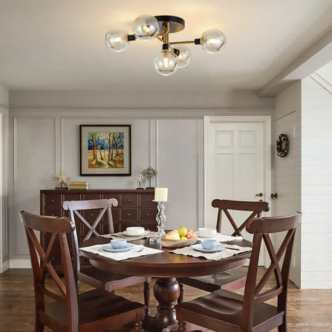 Five Light Black And Gold Brushed Metal Sputnik Ceiling Light With Glass Globes Semi Flush Mount in dining room setting.