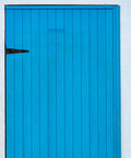 Beefy 8 Inch Black Iron Barn Door Hinges Extended T Shape Slotted Bearing Hinge on a blue door for sturdy installations