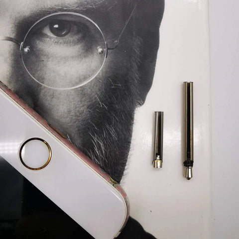 Pro Grade Headphone Jack Removal Tool Set with 20mm and 30mm stainless steel tubes placed next to a phone on a book