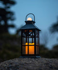 Solar Lantern Outdoor Waterproof Hanging Light For Garden Patio And Porch With Flickering LED Flames on rocky surface at dusk