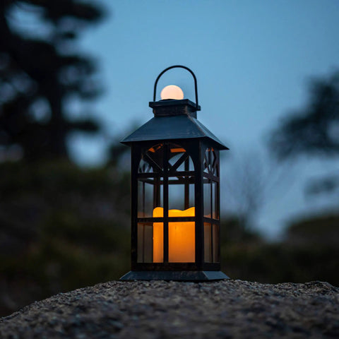 Solar Lantern Outdoor Waterproof Hanging Light For Garden Patio And Porch With Flickering LED Flames on rocky surface at dusk