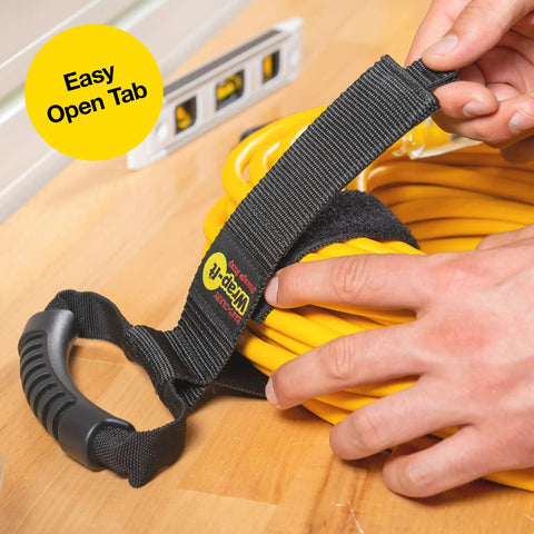 Close-up of a hand using Wrap-It Storage Straps 17-Inch 2-Pack Heavy-Duty Hook And Loop Cord Carrier with handle on yellow cord.