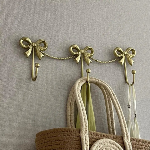 Kickass Heavy Duty Wall Mounted Coat Hook Bulletproof Metal Clothes Hanger with decorative bows holding bags.