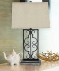 Metal Table Lamp With A Stacked Rectangular Base, Dope Scrollwork, And A Rectangular Shade For Modern Home Decor on table