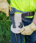 Worker wearing leather riveted spud wrench holder with tunnel connection for dual spud wrenches and adjustable head construction wrench.