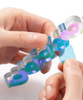 Hands holding Pro Grade Magnetic Nail Stand For Press Ons With Thick Base And Taller Pegs Anti Tip Acrylic Nail Holder