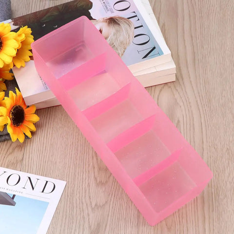 Solid Plastic Underwear Organizer Box With Five Grid Dividers For Closet Drawer Storage, pink design on wooden surface.