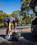 Pro Level Electric Golf Cart With Smart Remote Control And All Terrain Grip, user loading into car trunk.