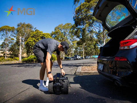 Pro Level Electric Golf Cart With Smart Remote Control And All Terrain Grip, user loading into car trunk.