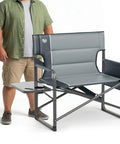 Man with the Beefy Heavy Duty XXL Director's Chair With Extra Wide 32 Inch Seat And 500 Lb Capacity, padded armrests, foldable design.