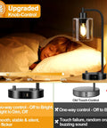 Set Of 2 Industrial Table Lamps With USB C And USB A Ports And Outlet, shown by a bed with one lamp illuminated.