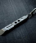 Titanium Ti Pry Mini Pry Bar Keychain EDC Pocket Pry Tool With Bottle Opener on dark background