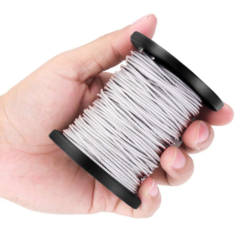 Hand holding vinyl coated stainless steel picture hanging wire from the kit with fifty aluminum crimp sleeves ten thimbles and fifty D ring hangers