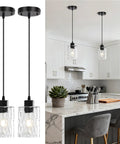 Two Pack Black Hammered Glass Pendant Lights With Adjustable Cords For Kitchen Island above a marble countertop in a modern kitchen.