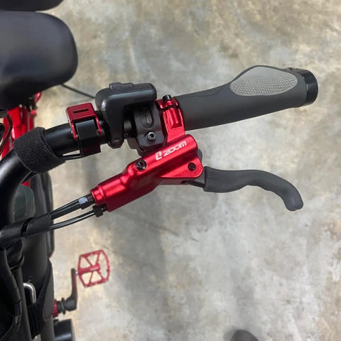 Close-up of handlebar with red brake lever from HB876E 4 Piston Ebike Hydraulic Disc Brake Set With Power Off Sensor 160mm Rotors