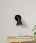 Black Wireless Led Wall Sconces Set Of Two With Remote Control Dimmer And Auto Timer Zero Drilling Hassle Straight Forward Battery Mount on a wall above a wooden table.