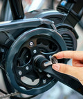 Person installing Six 8mm Hex Crank Arm Bolts With Caps For Square Cranksets, Durable Metal Construction on a bicycle.