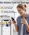 Woman viewing Wireless 2K Doorbell Camera With No Subscriptions on smartphone in living room, holding cup with instant alerts visible