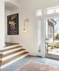 Entryway with Mid Century Modern Wall Light With Adjustable Cord Raw Brass Round Glass Sconce and Amber Lampshade
