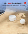 Mini Nano Smoke Detector next to a golf ball on a wooden surface, showcasing sleek design for home safety.