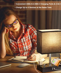 Woman using Dope Dual USB Dimmable Bedside Lamp With Phone Stand And Type C Charging Ports Black Desk Lamp For Nightstand