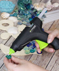 Person using Full Size Hot Glue Sticks 50 Pack Clear Non Toxic Multi Temp 4 Inch By 0.43 Inch for DIY crafts with a glue gun
