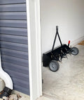 Tow Behind Plug Aerator With Folding Easy Store Tow Bar, 42 Inch Working Width, parked in a garage corner