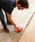 Man using Floor Suction Cup Tool For Quick Fix Strong Suction Wood Floor Fixer Plank Repair Grabber on tile floor installation