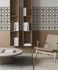 Scandinavian-inspired living room with geometric wallpaper, open wooden shelves, beige woven chair, and modern circular coffee table.