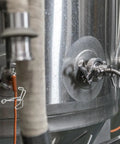 Spring Flow Control Tube Clamps With Bracket Feet installed on a metal tank for lab and classroom use, featuring leak resistant clips.