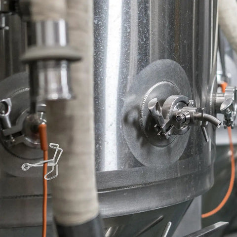 Spring Flow Control Tube Clamps With Bracket Feet installed on a metal tank for lab and classroom use, featuring leak resistant clips.