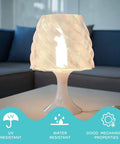 Table lamp with a twisted shade made from transparent 3D printed polycarbonate, showcasing UV and water resistance benefits.