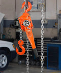 Orange 3 Ton Lever Chain Hoist 10 Ft Lift G80 Galvanized Carbon Steel Weston Double Pawl Brake hanging in garage