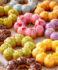 Colorful assortment of decorated donuts on parchment, showcasing vibrant flavors and styles for bakery delight.