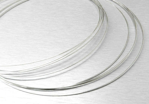 No Hassle Pro Grade Easy Flow Silver Solder Wire, 20Ga, 56% Silver, 5 ft shown coiled on metallic surface for jewelry making.