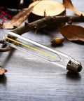 Dimmable T10 LED Filament Tubular Bulb 3000K Warm White Edison Style Dope Retro Vibe, clear glass, E26 base, on wooden surface