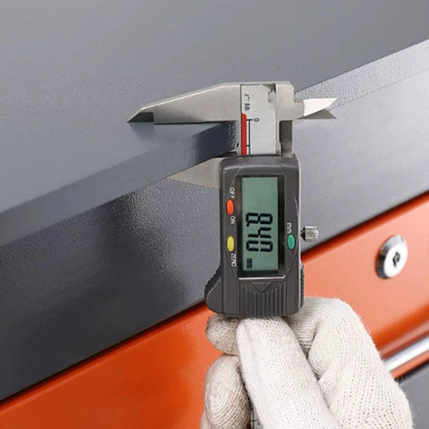 Measuring the thickness of the heavy hitting steel top workbench built like a tank with a digital caliper