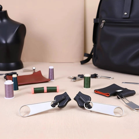 Universal Zipper Repair Kit 24 pieces with zipper sliders and sewing tools on a table, black bag in the background