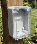 Awesome 6-Pack Waterproof Electrical Enclosure Boxes Built To Last For Outdoor Security Systems mounted on a wooden post.
