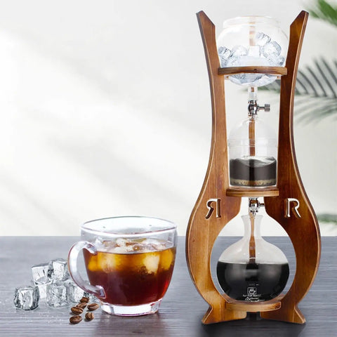 Big Batch Cold Brew Coffee Maker With Detachable Glass Tower And Solid Wood Frame No Fuss Drip Iced Coffee Brewer With Dual Adjustable Valves displayed with brewed coffee and ice.