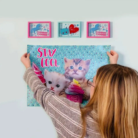Person hanging poster on wall painted with Magnetic Paint And Primer Water Based 32oz High Yield For Any Surface Make It Magnetic Easily Great For Kids Rooms Offices Walls Magnetic Photo Walls And Poster Displays Ready For Chalkboard Or Painted Surfaces