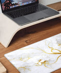 Boss Size Desk Pad For Gaming And Work 31.5 By 11.8 Inches Waterproof Thick Desk Mat With Grippy Non Slip Rubber Base White Gold Marble Flower on wooden desk next to laptop