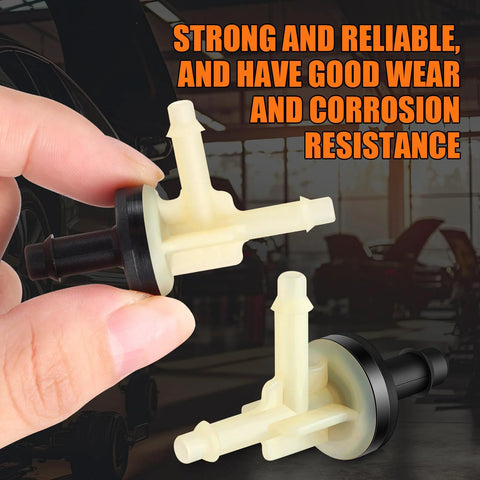 Front view of four beige plastic vacuum check valves for automotive vacuum lines, held in hand.