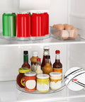 Two Pack Clear 9 Inch Lazy Susan Turntable Rotating Organizer Tray For Cabinet And Countertop Use Non Slip Round Spice Rack Refrigerator Kitchen Pantry Bathroom Storage with drinks and sauces in a fridge.