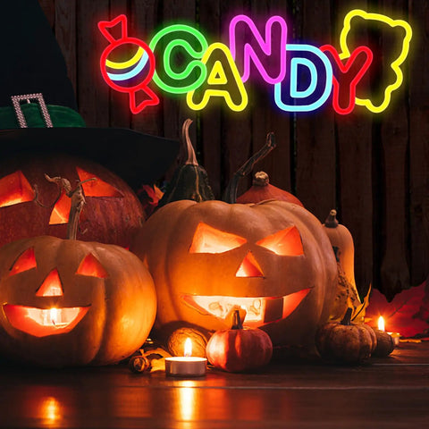 Halloween jack-o'-lanterns with glowing "CANDY" neon sign above, featuring colorful letters and pumpkin decorations.