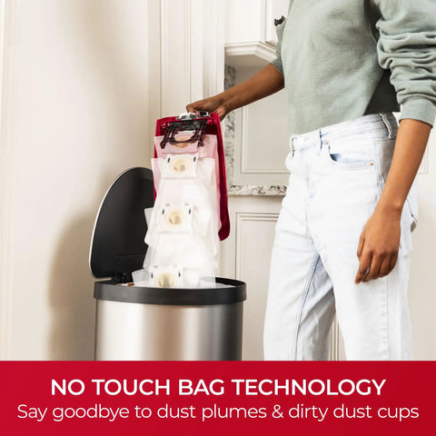 Hassle Free Bagged Upright Vacuum With No Touch Auto Dump, user disposing of sealed dirt bags into trash can.