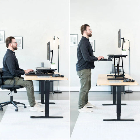 Man at desk using height adjustable 32 inch desk converter with sit to stand quick elevation tabletop dual monitor riser in office